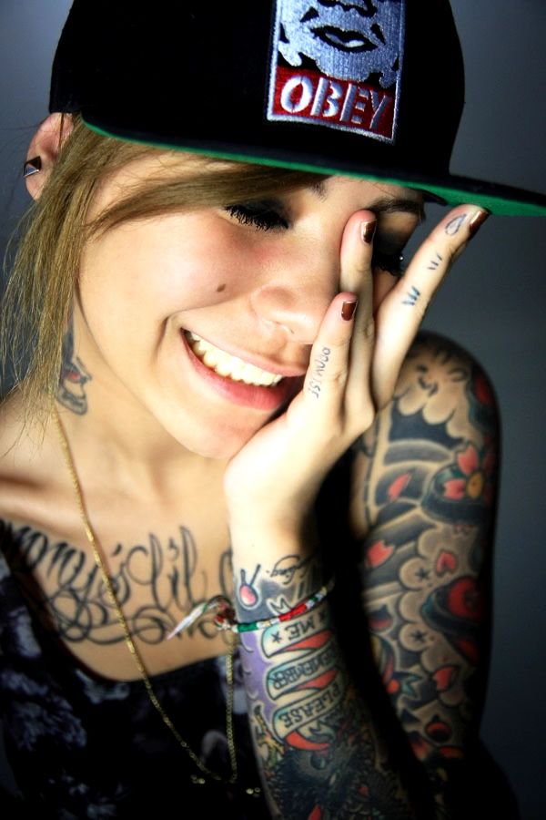Portrait jeune femme tatouée casquette OBEY rieuse