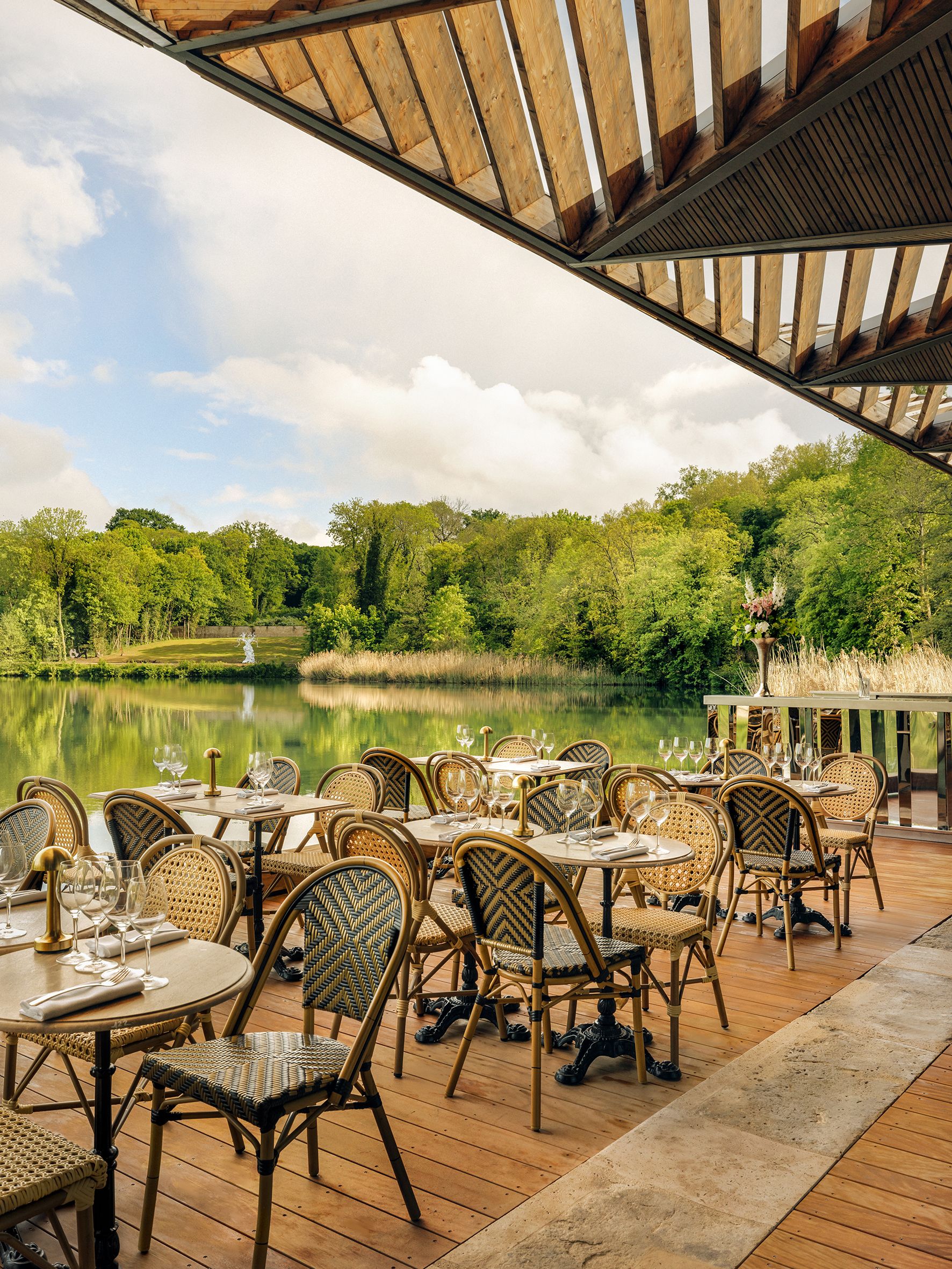 Terrasse de restaurant face à un étang verdoyant