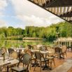Terrasse de restaurant face à un étang verdoyant