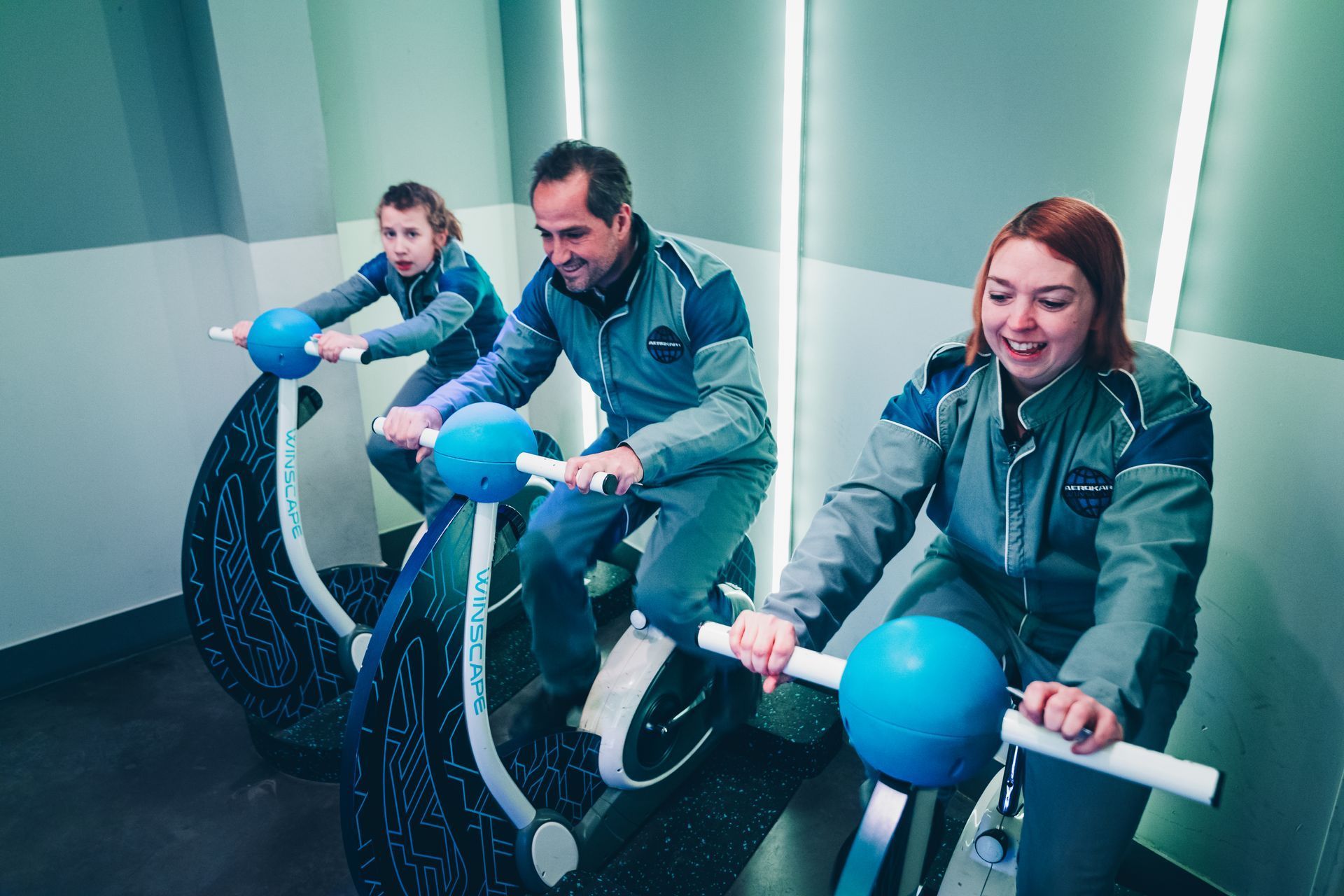 Famille pédalant sur vélos d'entraînement Winscape Aerokart