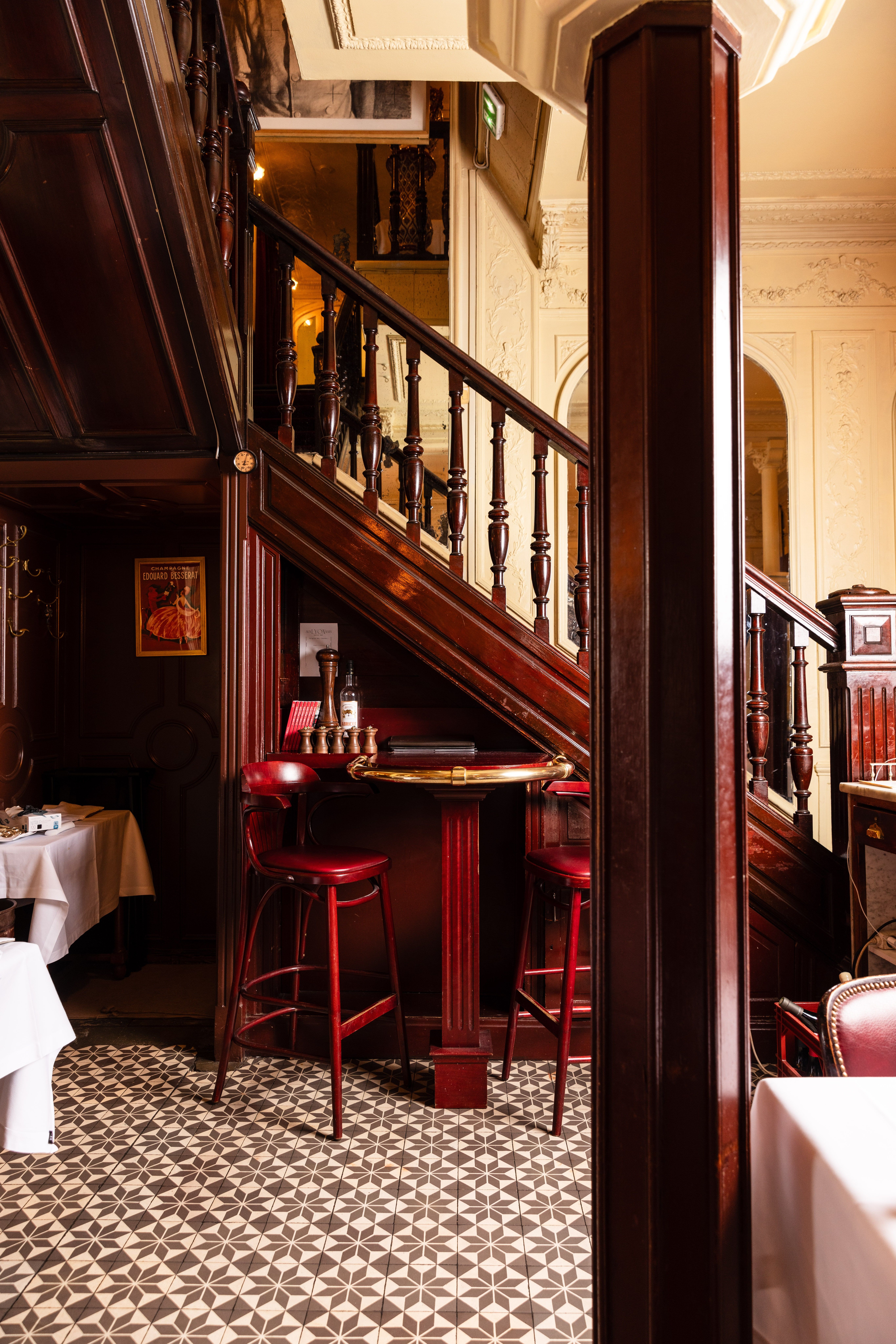 Bistrot parisien escalier bois et tabourets rouges