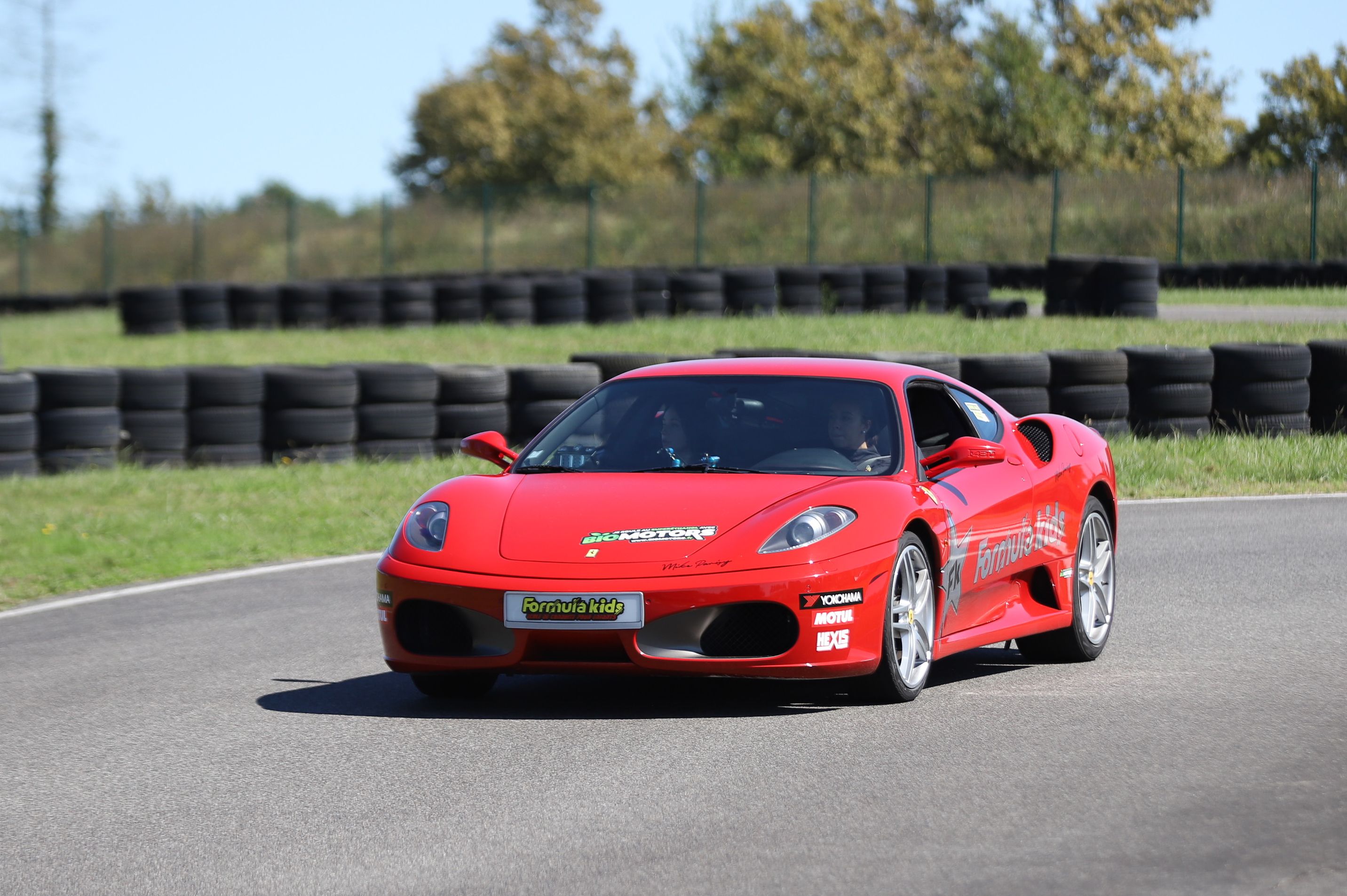 Ferrari F430 rouge en virage sur circuit auto