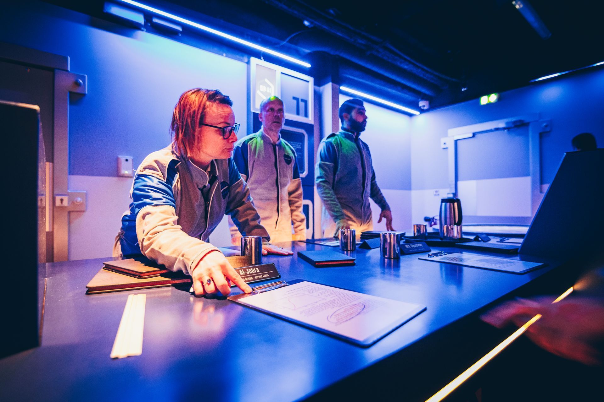 Escape game ambiance bleue avec joueurs concentrés
