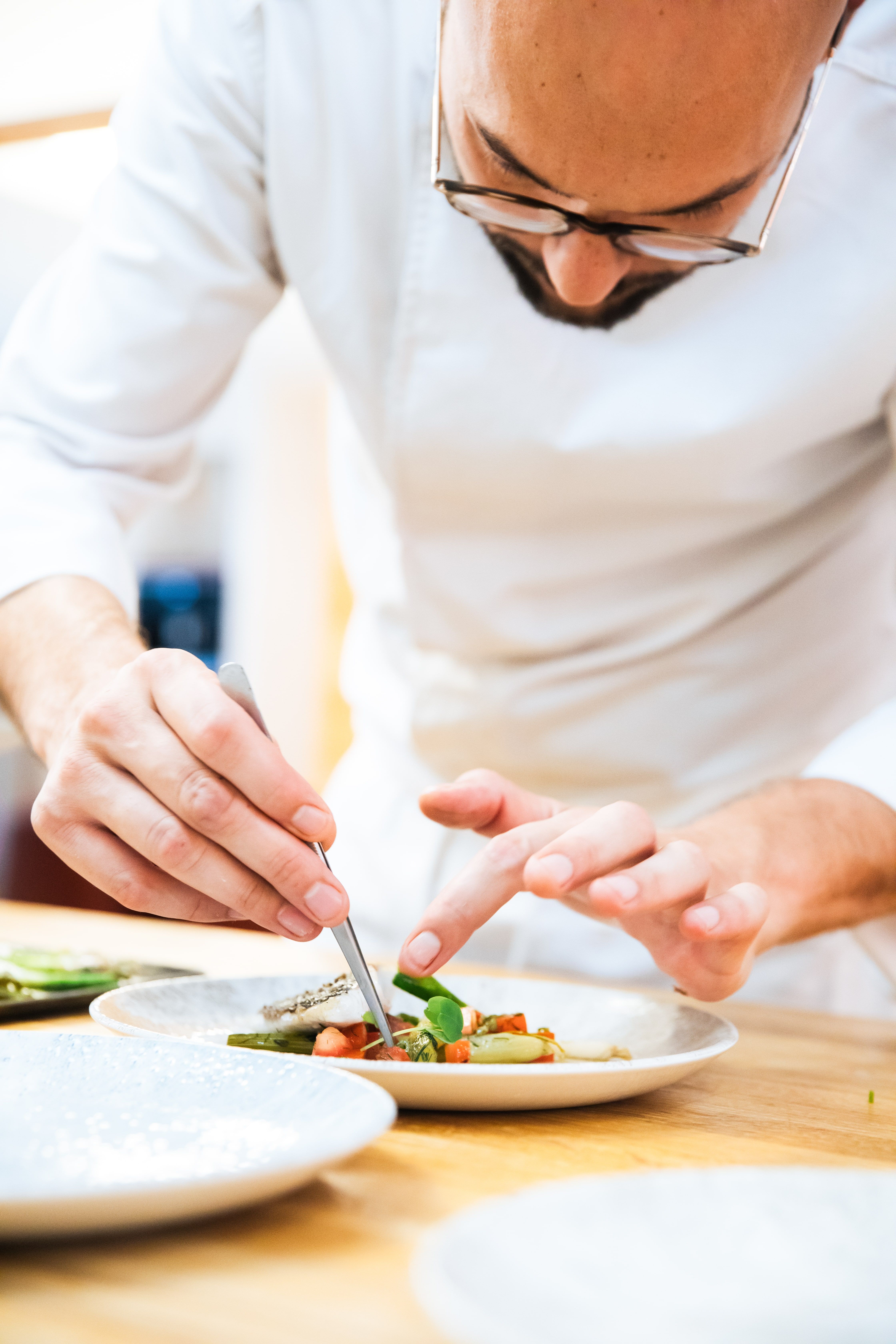 Chef dressant une assiette à la pince