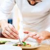 Chef dressant une assiette à la pince