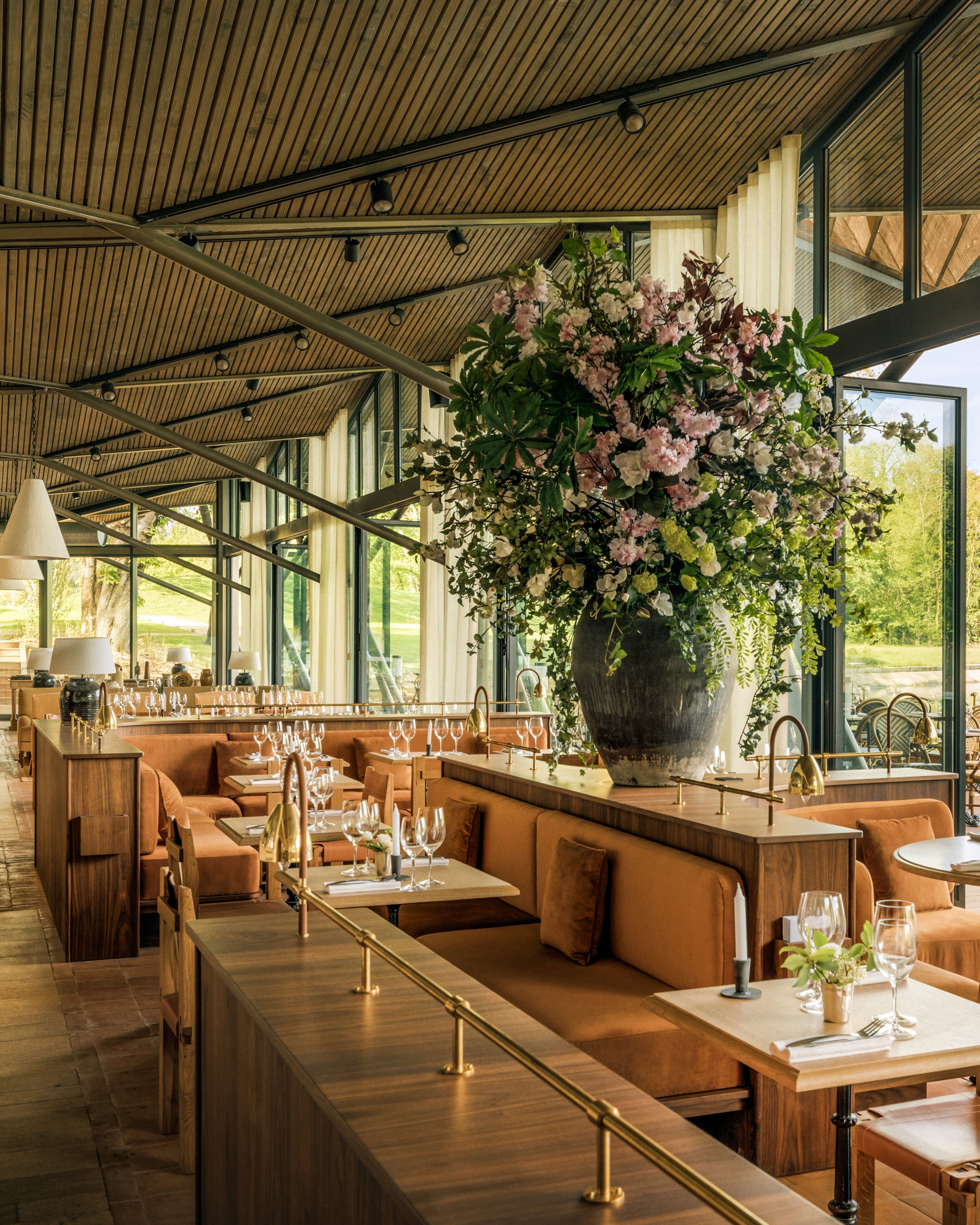 Salle de restaurant lumineuse banquettes velours et bouquet