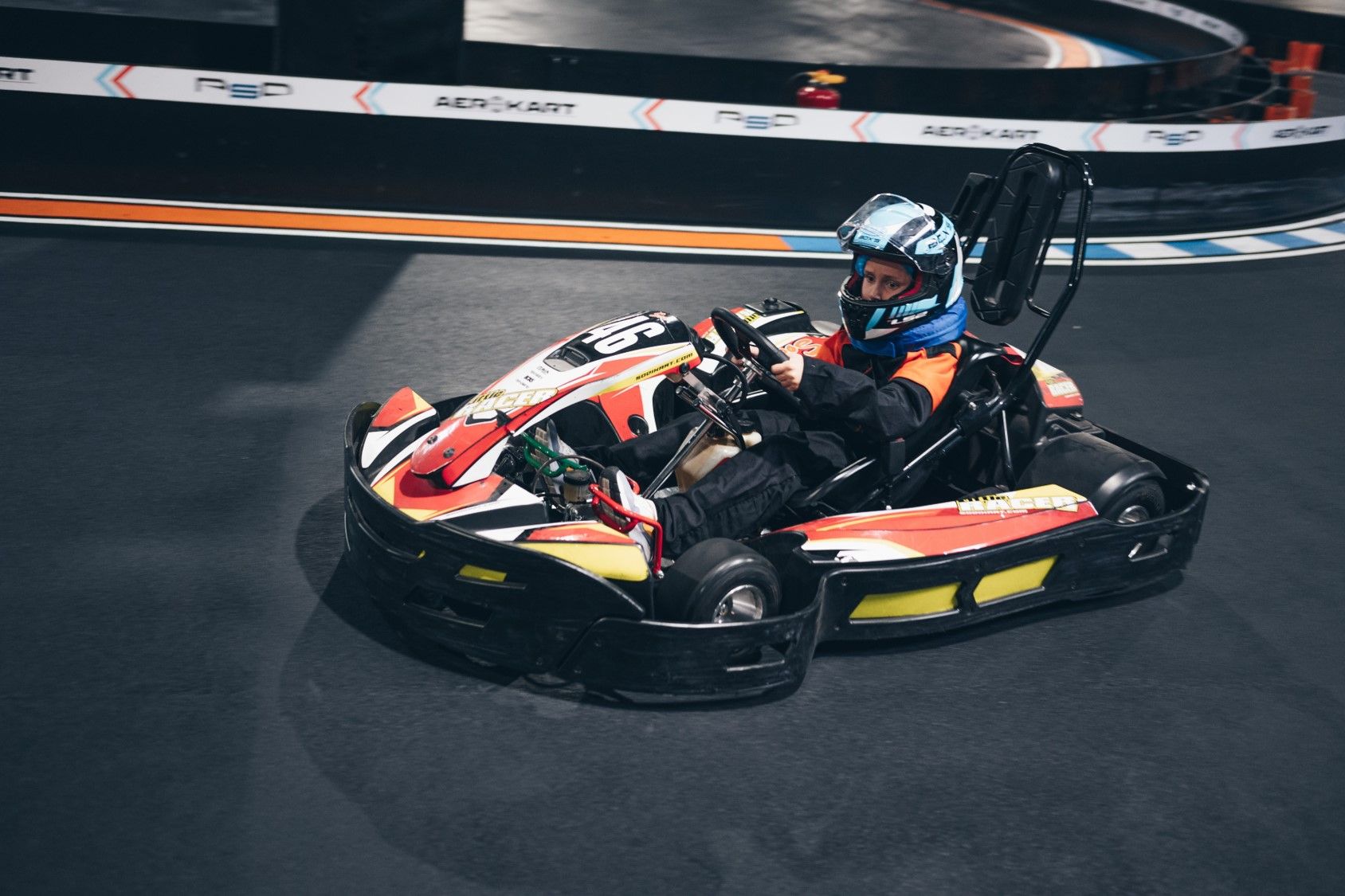 Karting indoor pilote casqué en pleine course