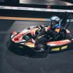 Karting indoor pilote casqué en pleine course