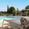 Piscine extérieure ensoleillée avec transats et palmiers