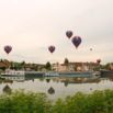 Montgolfières au-dessus d'un village au bord de l'eau