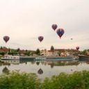 Montgolfières au-dessus d'un village au bord de l'eau