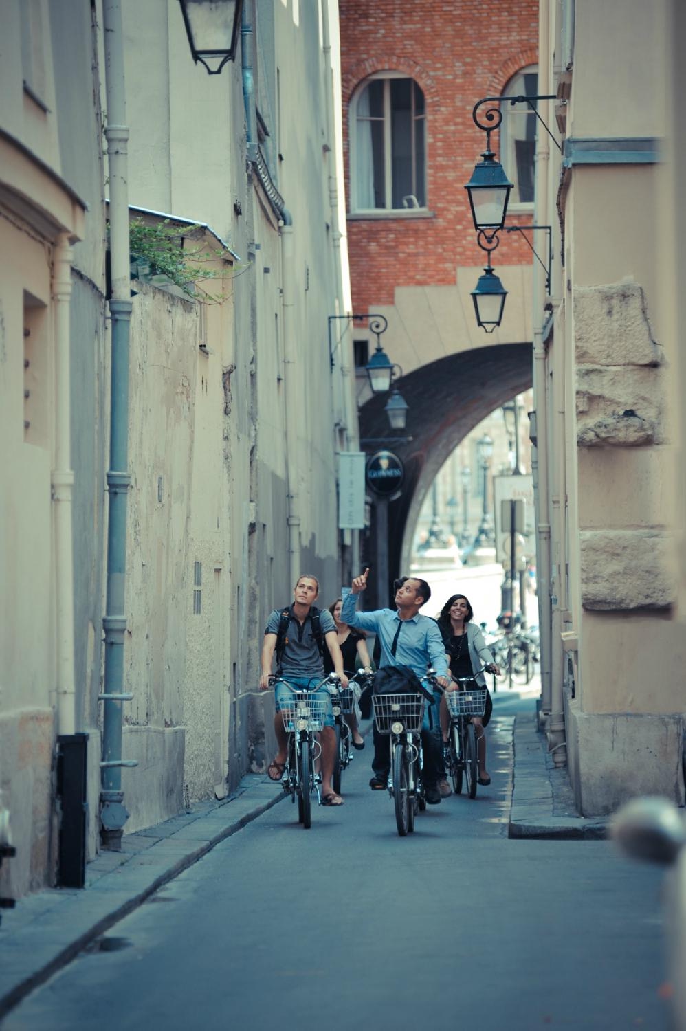 Balade vélo en groupe ruelle parisienne ancienne