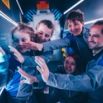 Famille à l'escape game en combinaisons bleues souriants