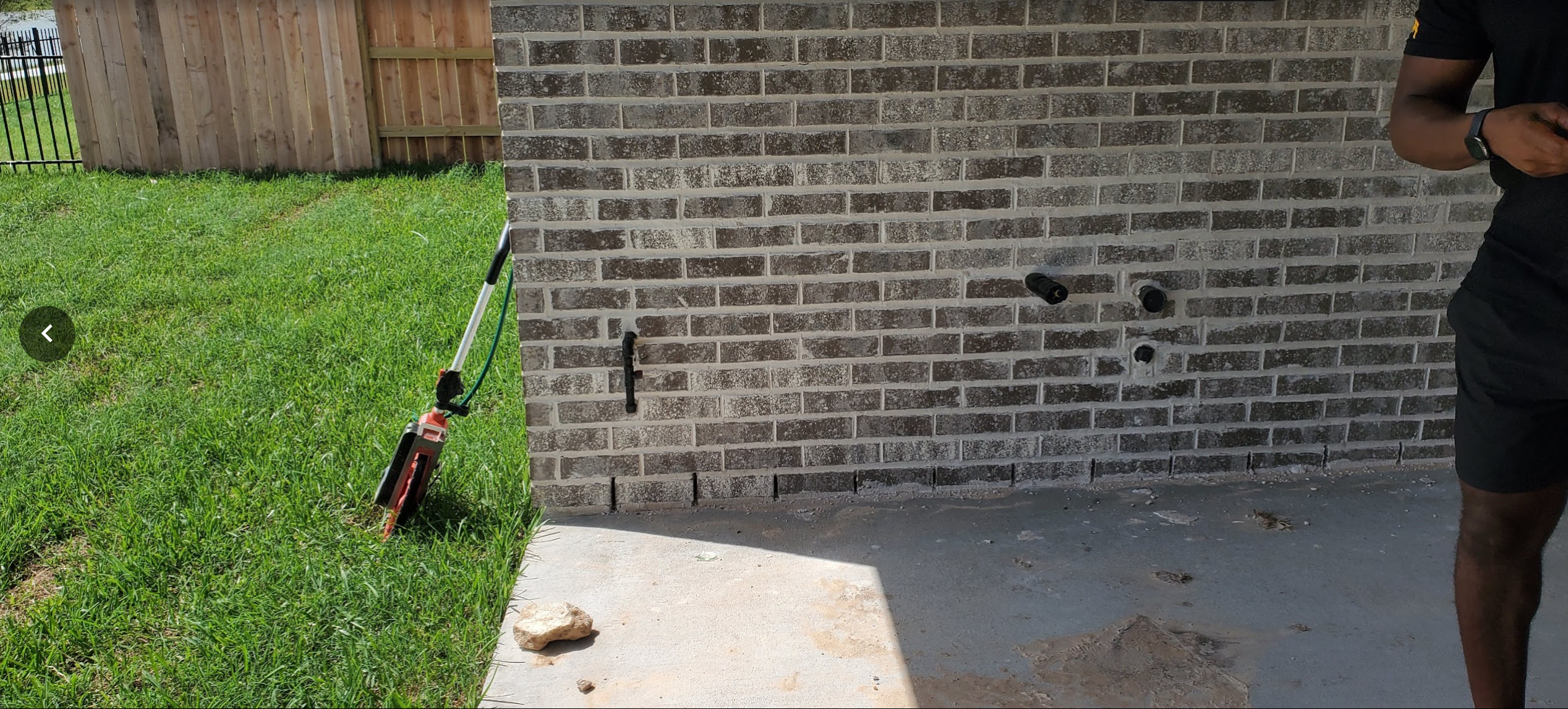 Existing concrete patio and adjacent grass area before backyard renovation
