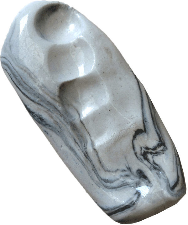 A marbled piece of clay showing indentation marks from being hand-squeezed