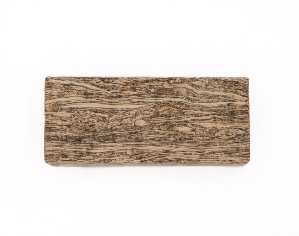 A rectangular block of engineered hemp lumber, its face densely striped with fine dark and cream fibre running lengthwise.