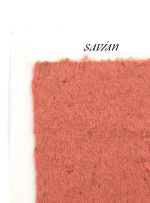 A square of dense coral-orange pile fur mounted on a white card printed “savian”, the fibres soft and slightly matted.