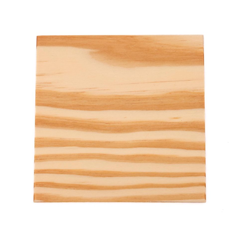 A square of yellow pine in pale honey, its grain running in broad wavy bands of cream and warm tan.