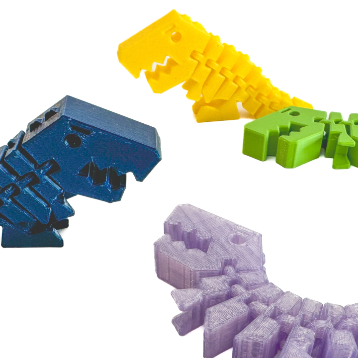 The four printed dinosaurs seen larger and separated — blue, yellow, green and lilac — the print layers visible along their segmented bodies.
