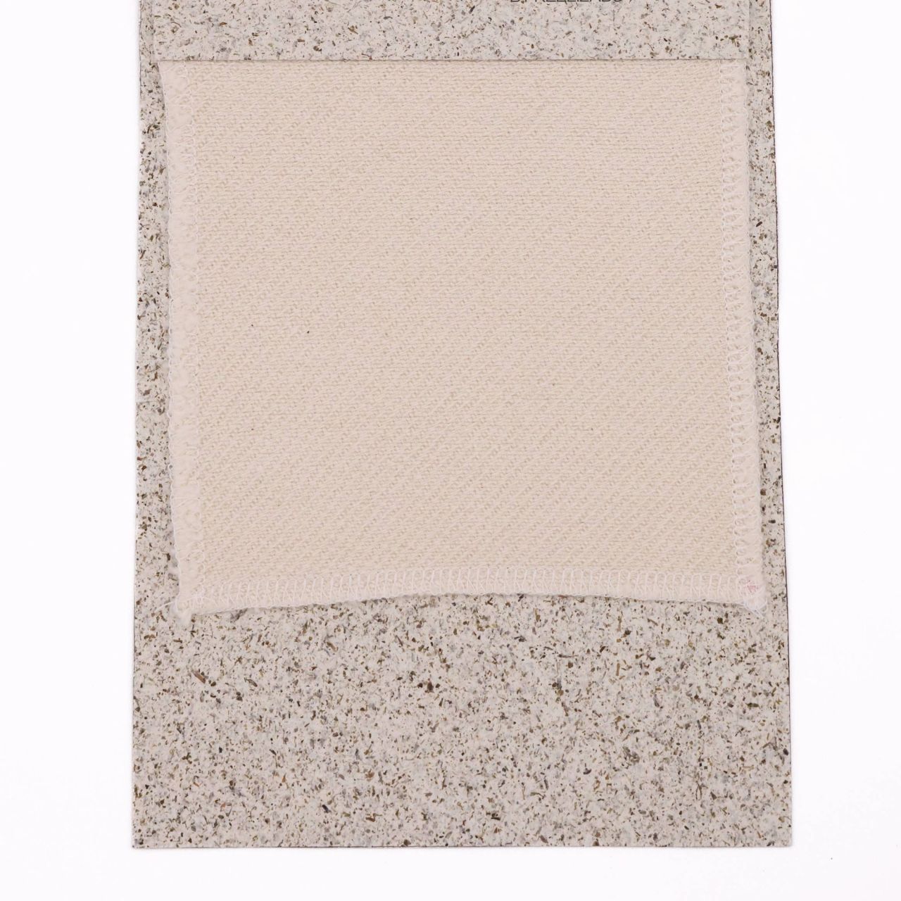 A cream woven swatch with a fine basket-weave texture, mounted on a speckled grey board.