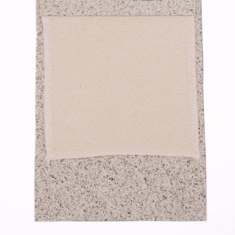 A cream woven swatch with a fine basket-weave texture, mounted on a speckled grey board.