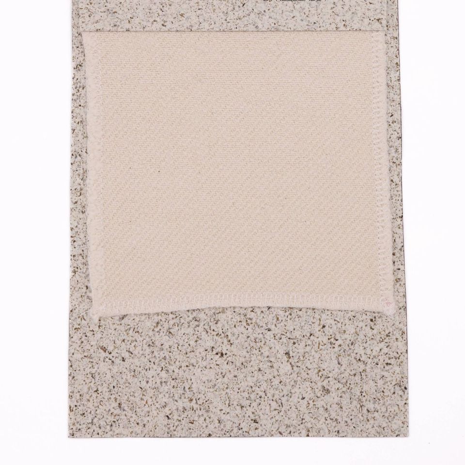 A cream woven swatch with a fine basket-weave texture, mounted on a speckled grey board.