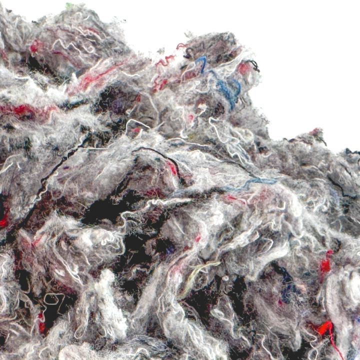 A close view of the fill, red and blue threads more visible among the grey fibres against the dark gaps between.