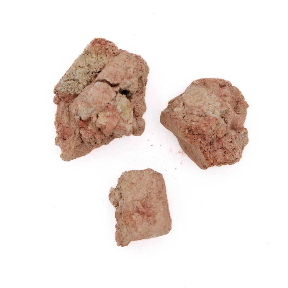 Three rough lumps of dry red clay, crumbly and coarse, their broken faces mottled with pinkish grey.