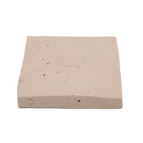 A square fired slab in soft greige, its surface smooth with a scattering of small dark specks and slightly uneven edges.