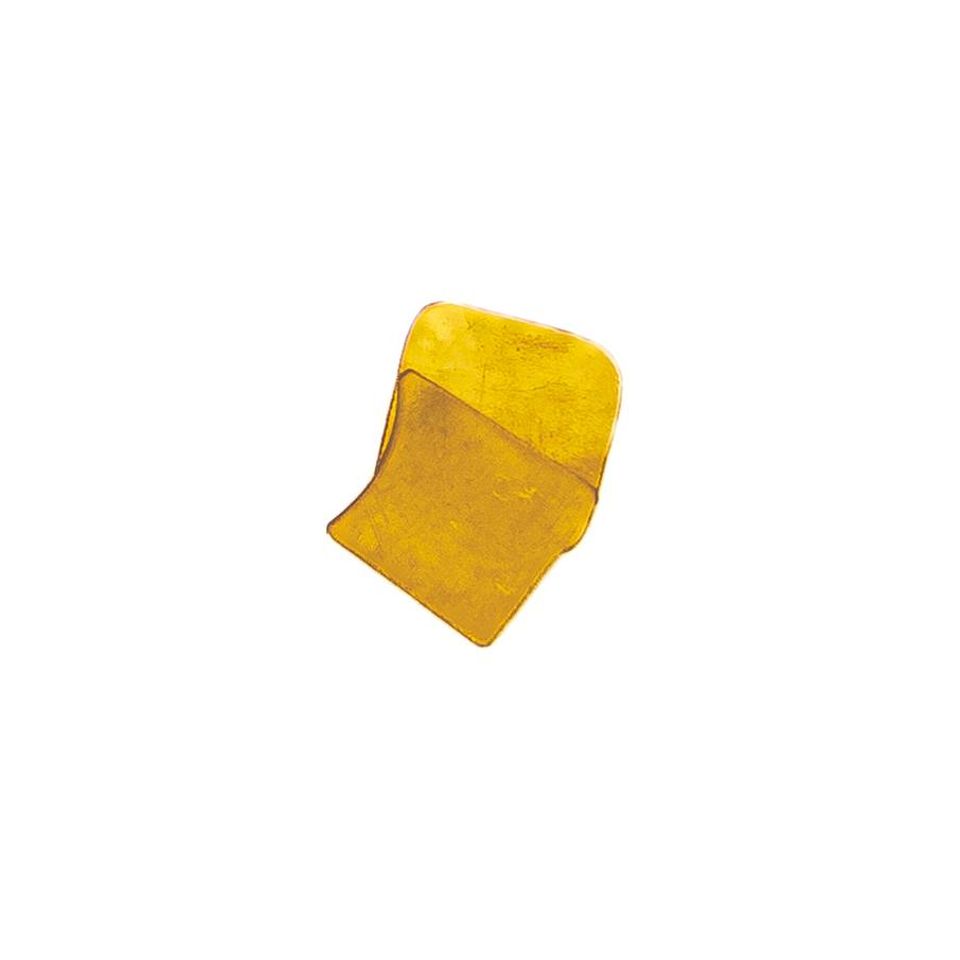 A small irregular sheet of brass in bright yellow-gold, its surface faintly mottled where the light catches, one edge curling upward.