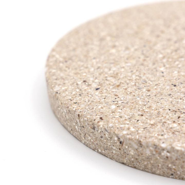 A close view of one edge, the crushed shell fragments coarse and distinct in cream, white and grey.