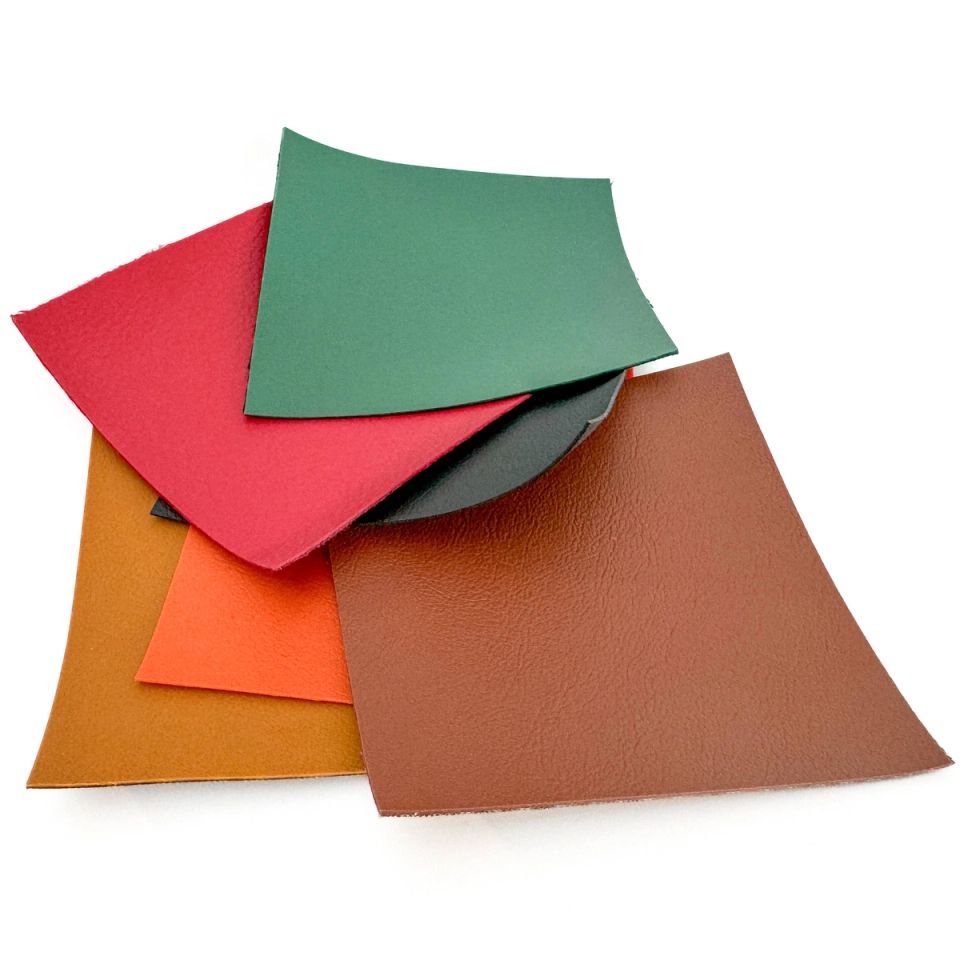 Five squares of supple bio-leather fanned across one another in green, red, ochre, orange and chestnut brown, each with a soft matte grain and slightly curling corners.