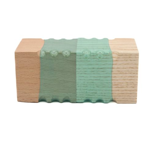 A rectangular block joining pale wood at each end to a mint-green plastic centre, the plastic moulded into fine vertical ridges with a row of small bumps along the top.