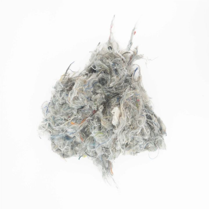 The same clump seen whole and further back, its outline ragged with stray fibres standing out.