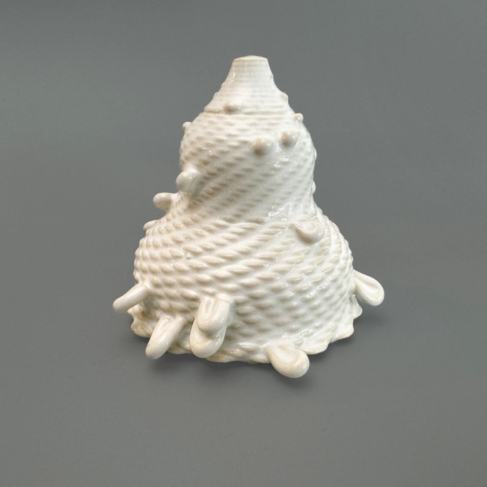 A conical, beehive-shaped vessel in glossy white glaze, its surface covered in regular raised bumps, with short finger-like nubs protruding around the base and lower sides.