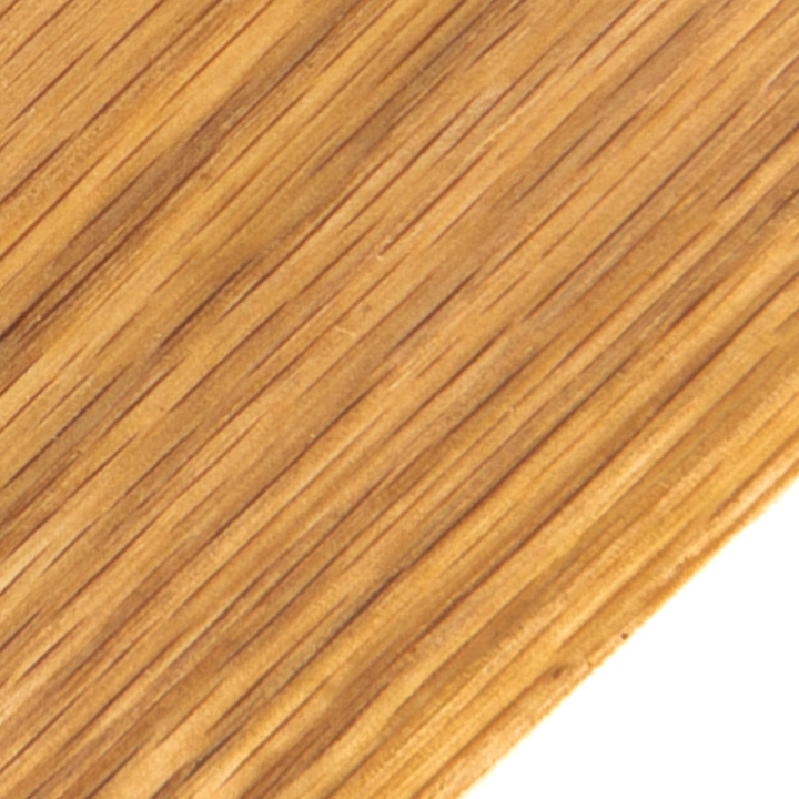 A close view of the grain running diagonally in fine dark lines across warm honey-brown, the board's corner at lower right.