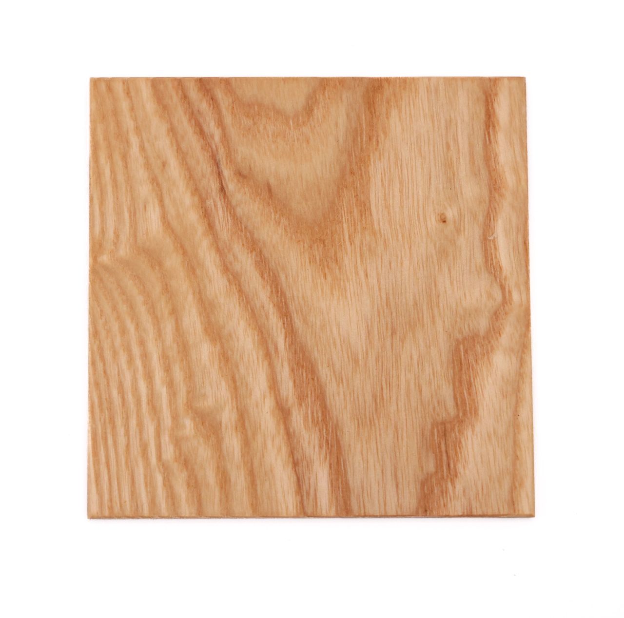 A square of pale golden ash, planed smooth, its grain arching in concentric bands across the face.