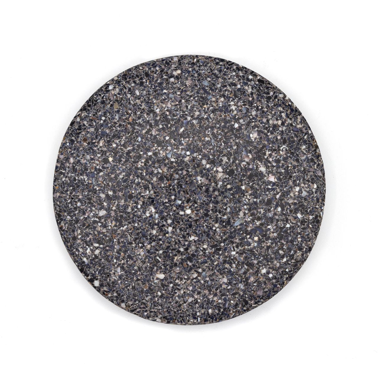 A round tile of dense composite, charcoal grey shot through with pale flecks of crushed shell in white, blue and brown.