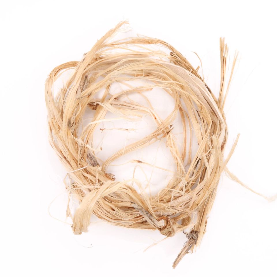 A loose coil of pale straw-coloured okra fibre, flat ribbons splitting into fine strands with woody fragments still attached.