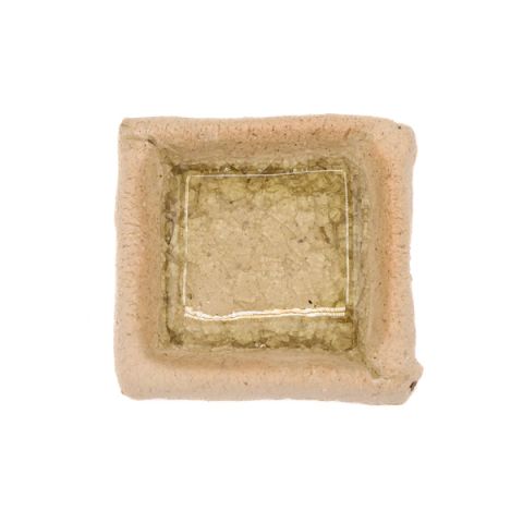 A small square test tile of buff stoneware with raised edges, its well filled with a pooled amber-olive glaze crazed into a fine glassy crust.