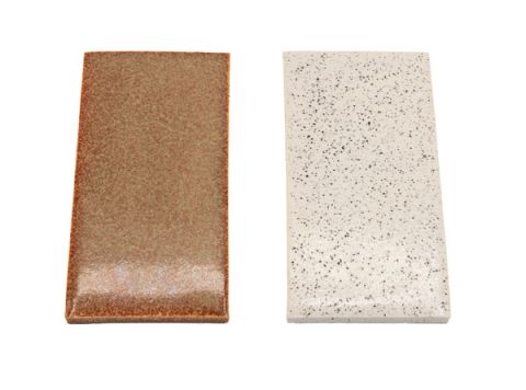 Two rectangular tiles side by side: one glazed in warm coppery brown with a metallic sheen, the other unglazed and speckled cream and grey.