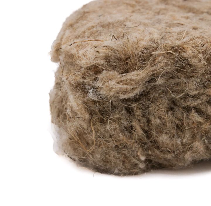 A close view of the pad's cut edge, the loose hemp fibres springing open where the batt has been sliced.