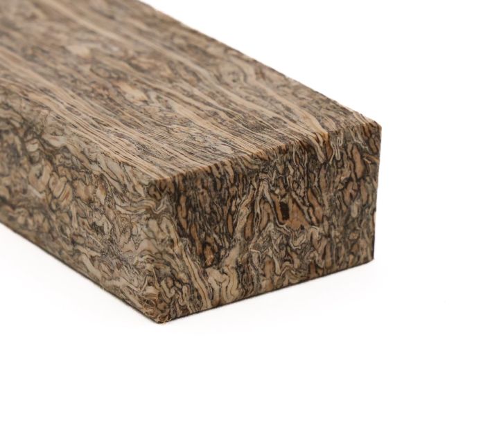 The block close from a corner, the tight vertical fibre striping on the long face meeting the swirled end grain.
