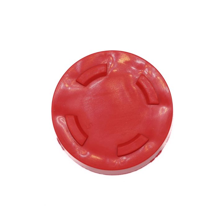 The cap from directly above, its moulded cross-shaped ribs and glossy pearlescent surface filling the frame.