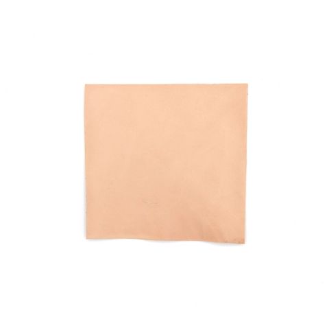 A square of chrome-tanned bison leather in soft blush pink, its surface smooth and matte, one corner curling slightly.