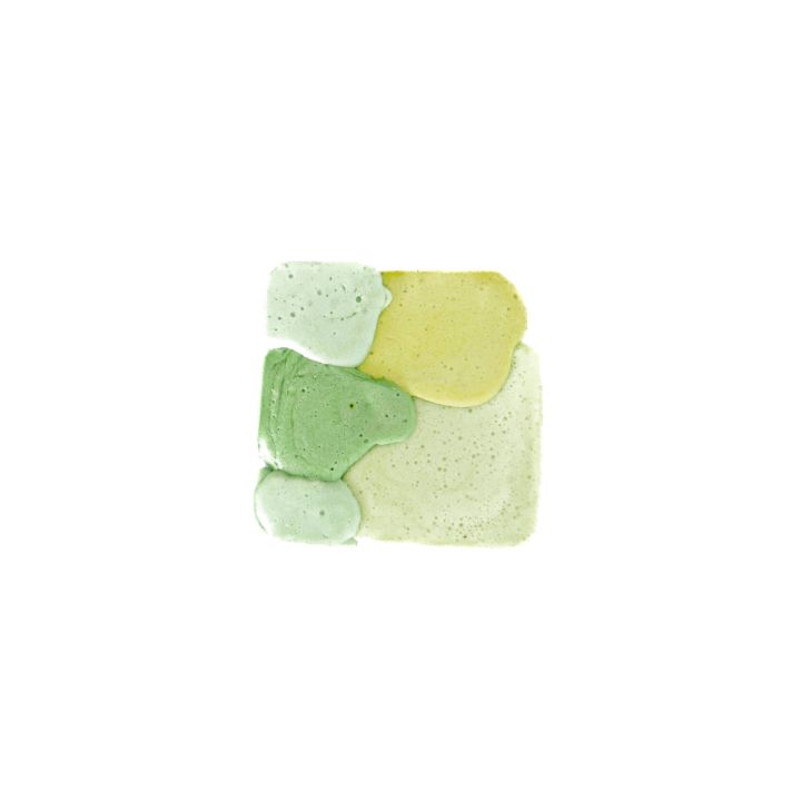 A single square of moulded foam in blocks of pale and deep green with a yellow-green wedge, its surface finely bubbled.