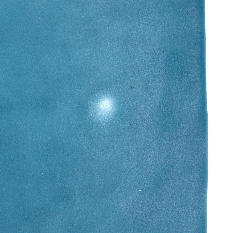 A tall translucent column in pale aqua, its sides faintly rippled, standing on a small dark walnut plinth.