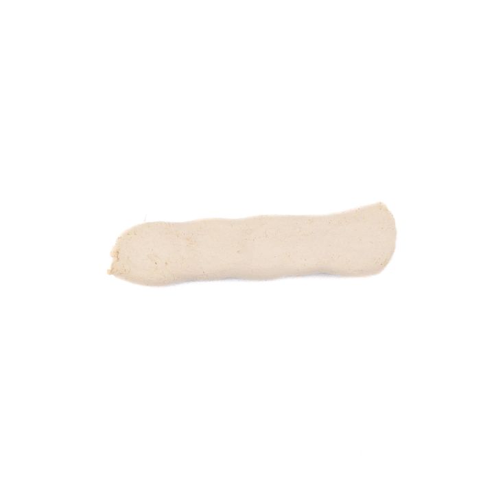 The clay coil from directly above, flattened into a broad pale strip with soft finger marks along its length.