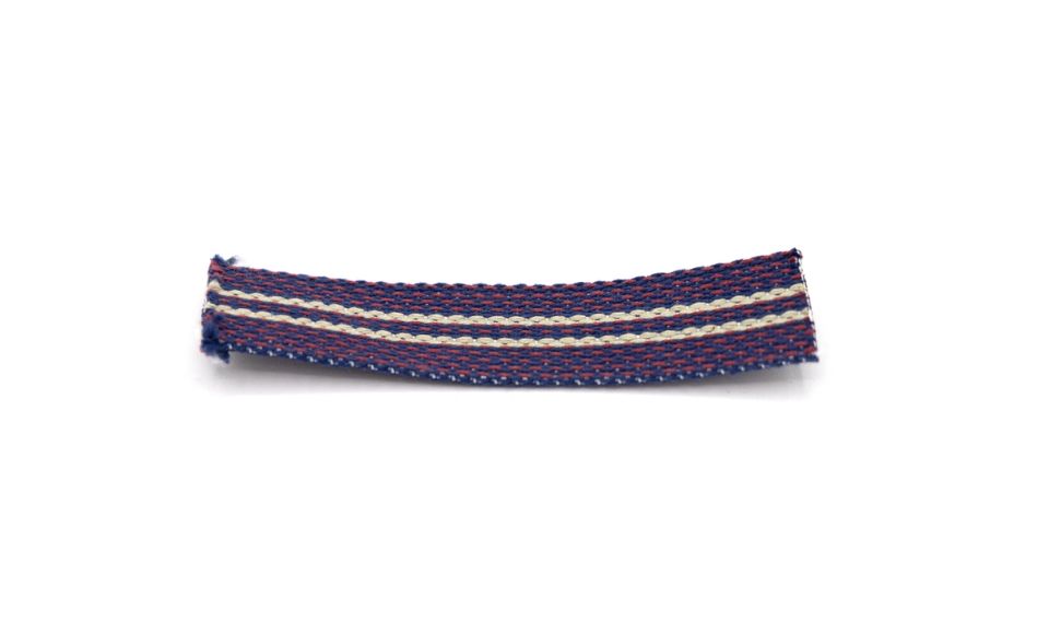 A short length of woven tape in navy and burgundy with a cream stripe down the centre, its cut ends fraying.