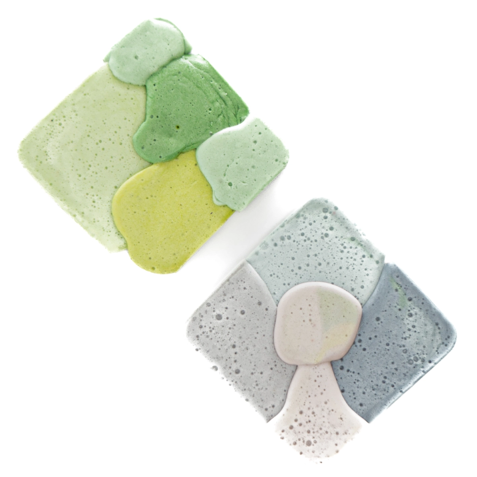Two squares together — one in greens and yellow-green, one in blue-grey with a pale mushroom-shaped inset — both pitted with fine bubbles.